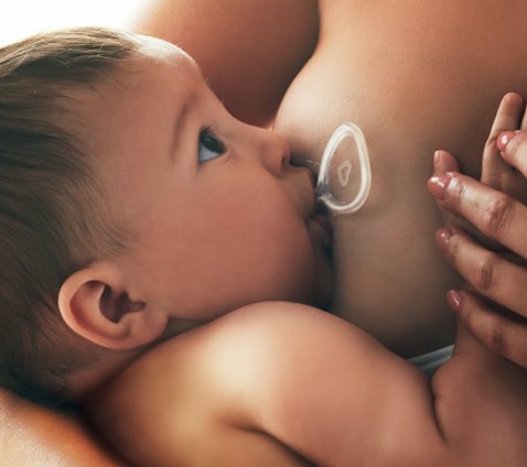 Close-up of baby latched on Flow shield